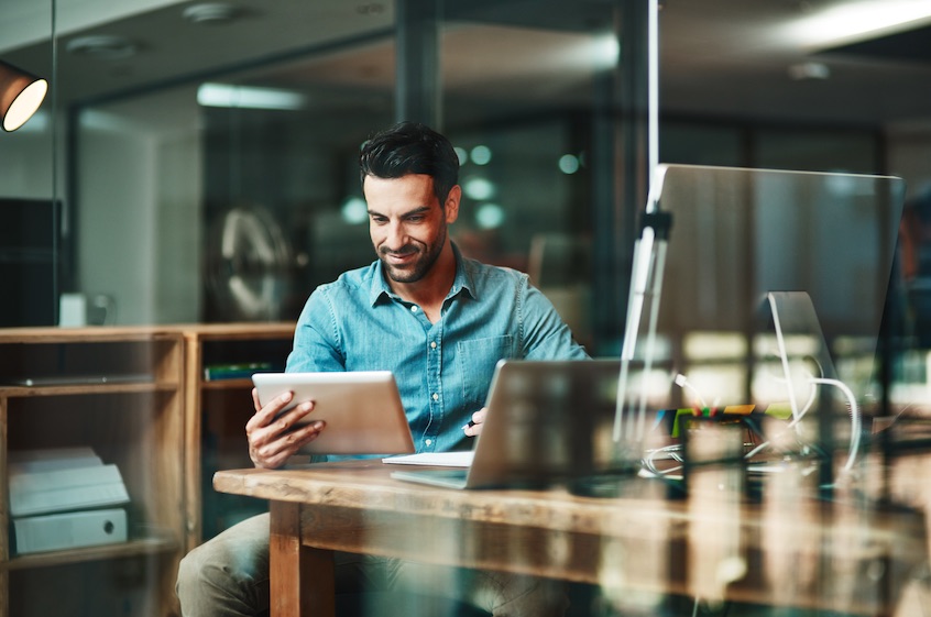 Office worker smiling at their mobile tablet