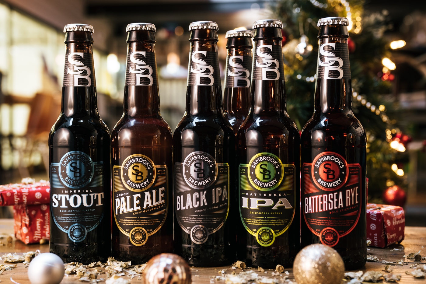Variety of Sambrooks Brewery beer bottles lined up with festive background