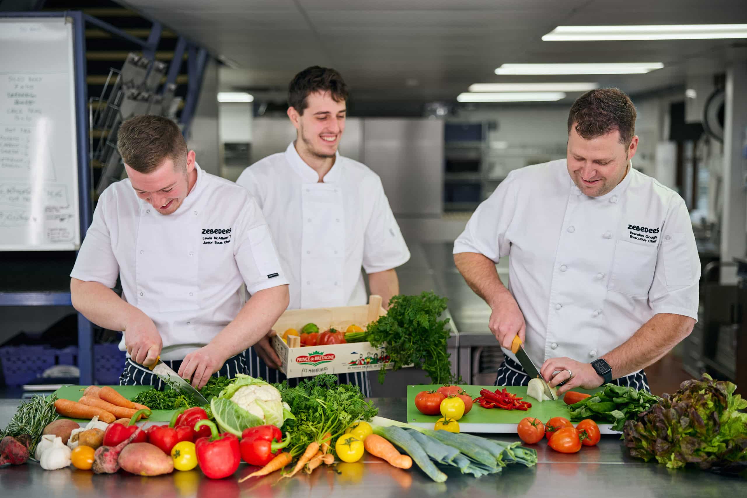 Image of Zebedees chefs chopping fresh, brightly coloured vegetables
