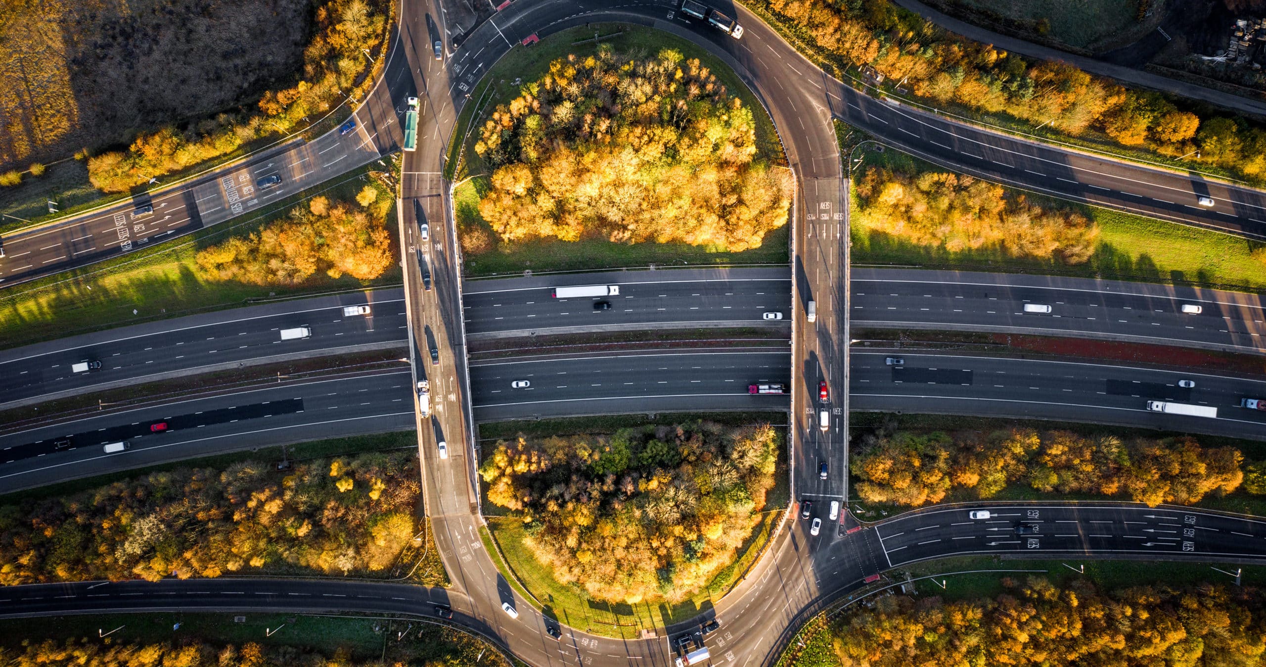 Aerial view directly above an overpass roundabout on the junction of the M1 motorway in a countryside environment