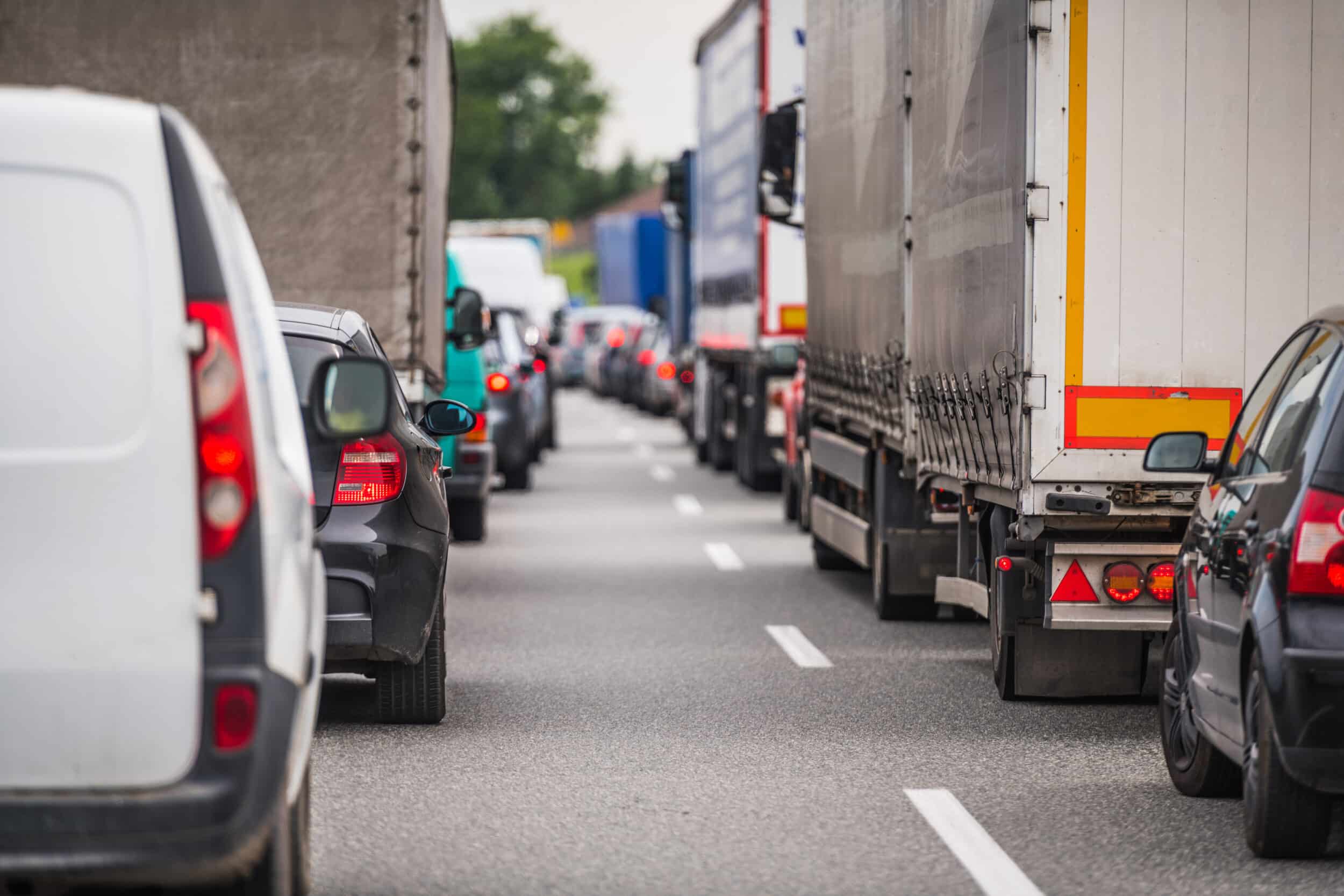 A busy road with a mixture of cars and delivery vans
