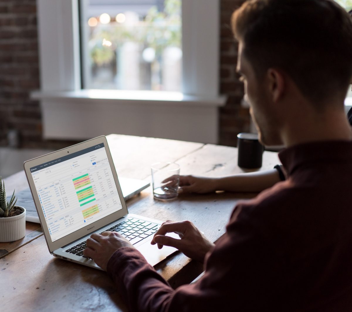 man sitting at laptop with maxoptra software displayed on laptop screen