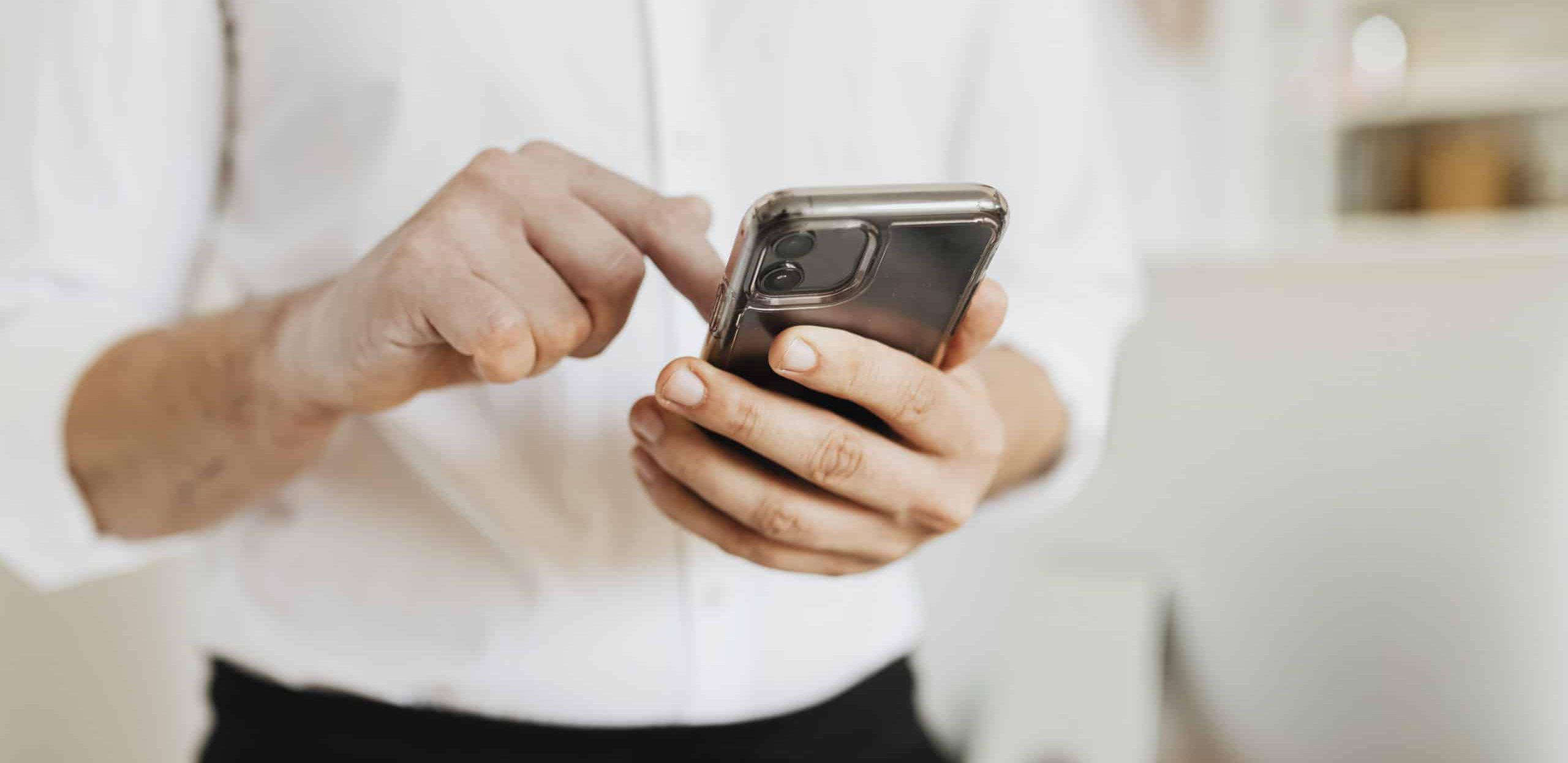 Person in suit checking their mobile phone