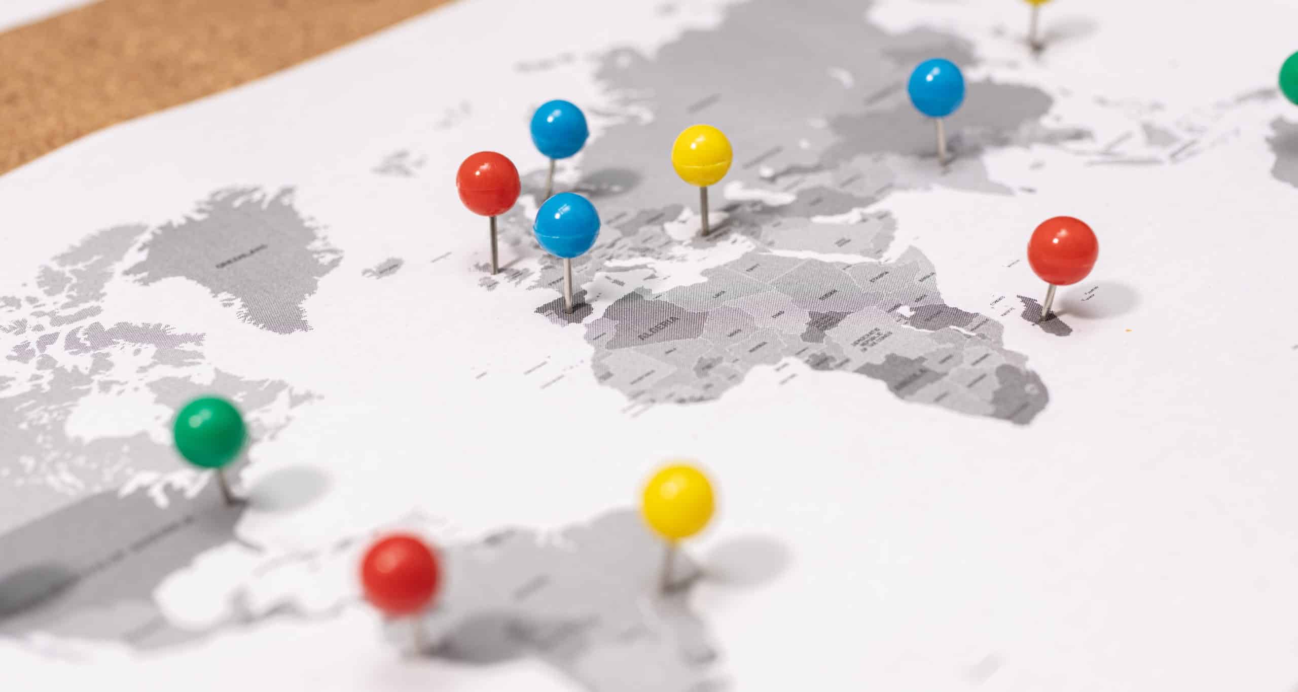 Image of multi coloured pushpins on a world map