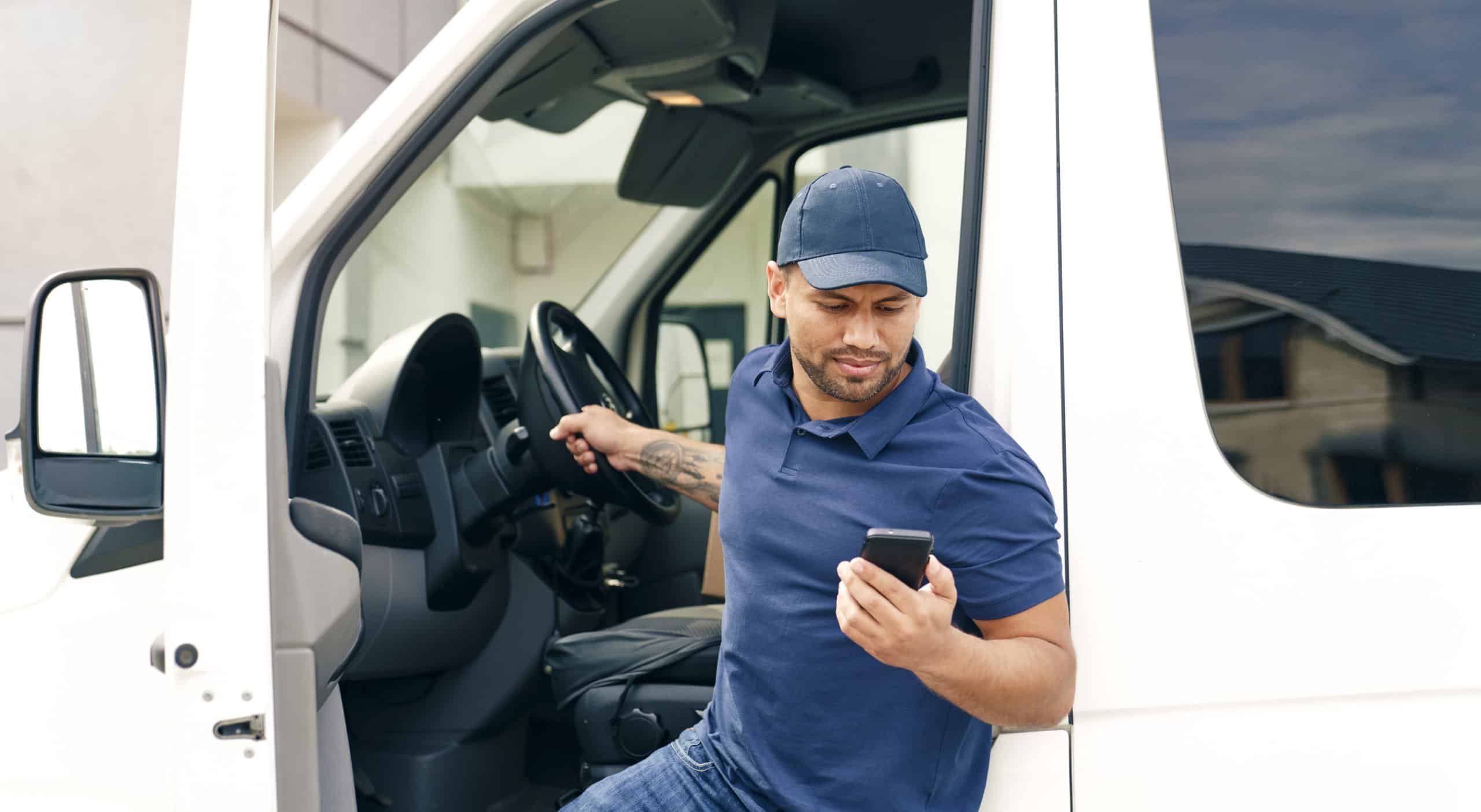 Delivery person with phone gets out of the car