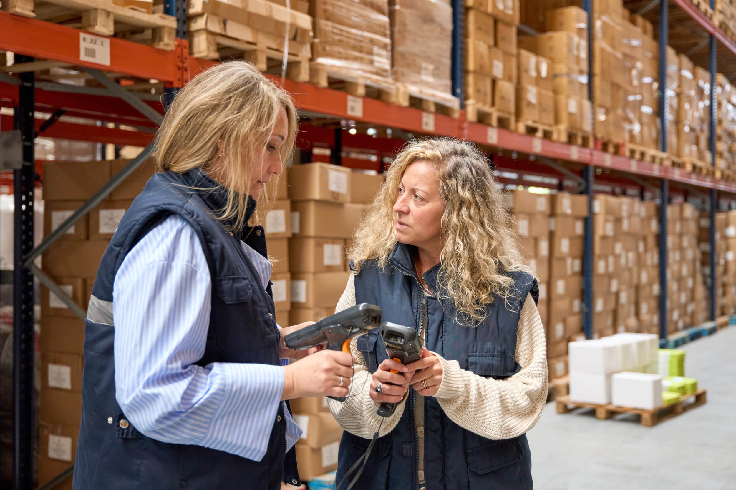 Two women in warehouse training on barcode scanners