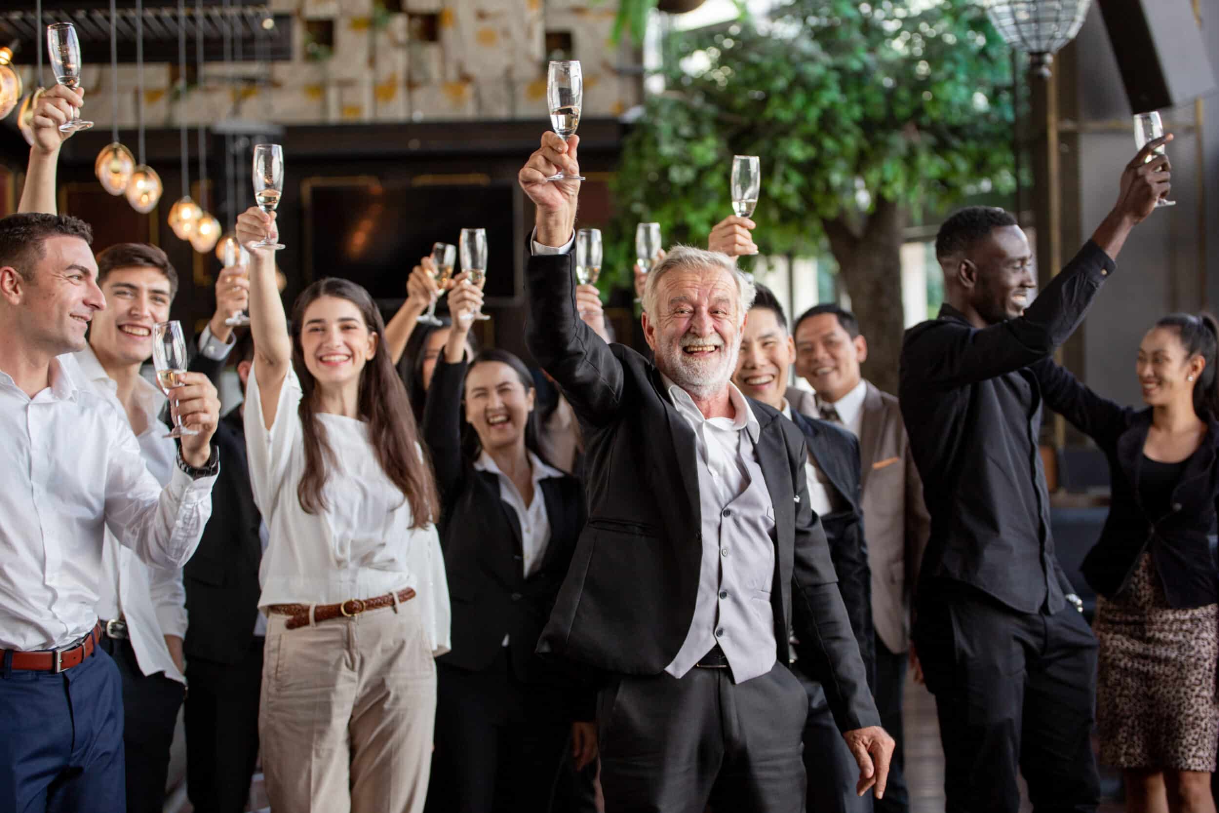 A business celebrating their successes by raising glasses of champagne and cheering