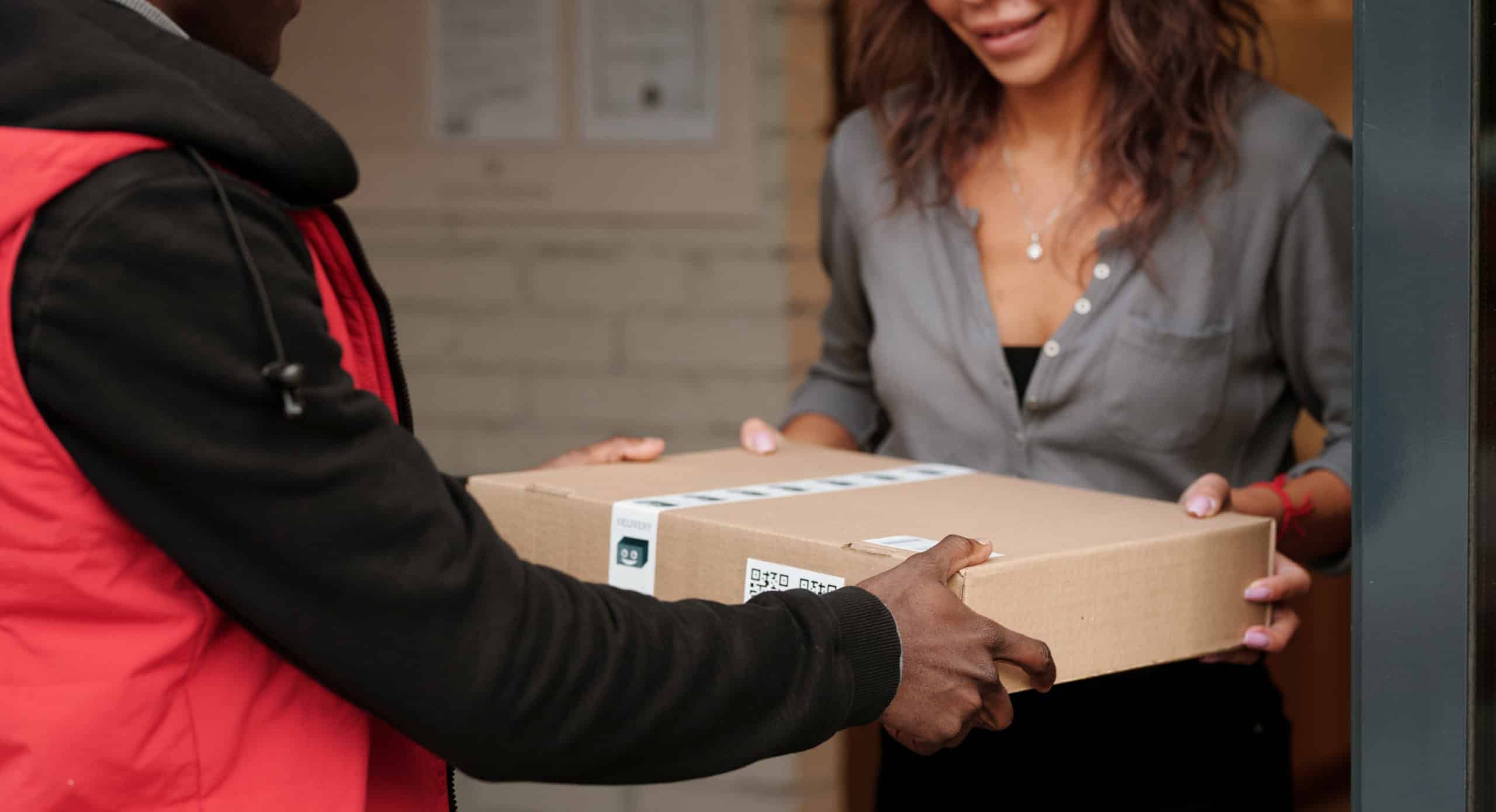 Delivery driver handing a parcel to a female customer
