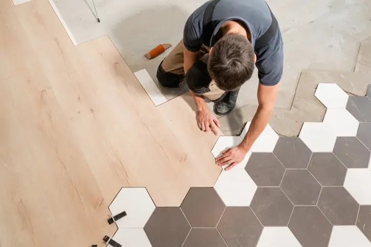 A man lays hexagonal tiles.