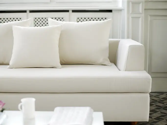 A white couch with a white coffee table in front.