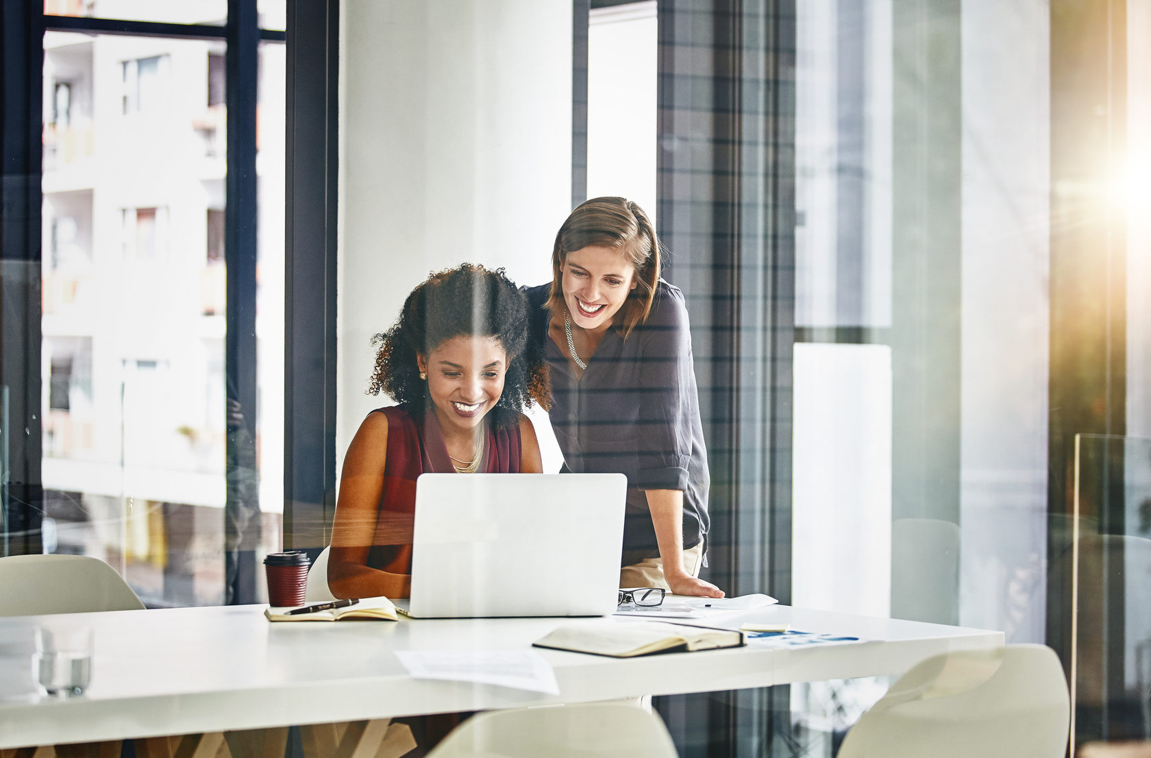 Office workers discussing work on a laptop