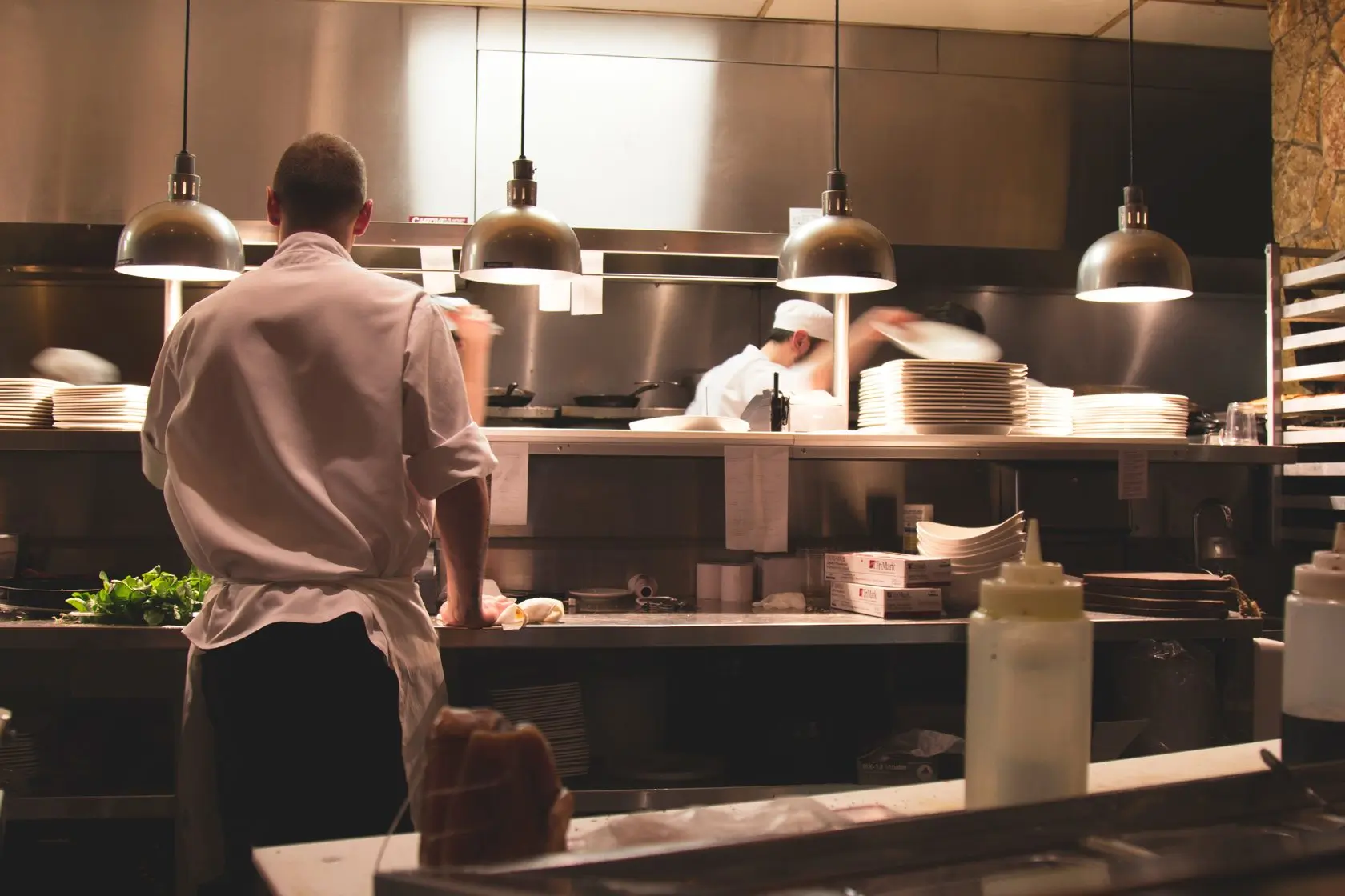 Two chefs work in a commercial kitchen.