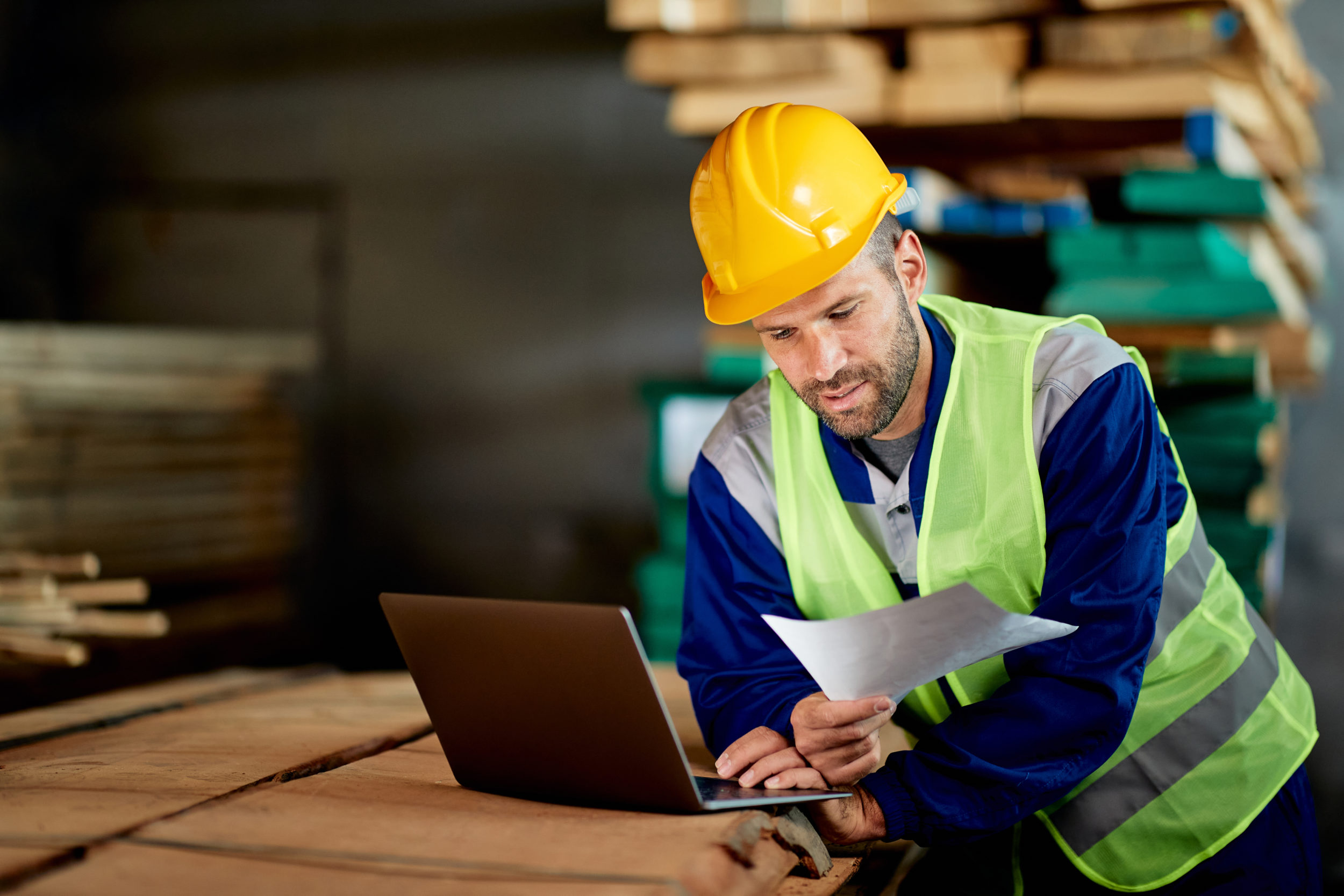 Transport planner in warehouse using his laptop to research can ChatGPT plan delivery routes