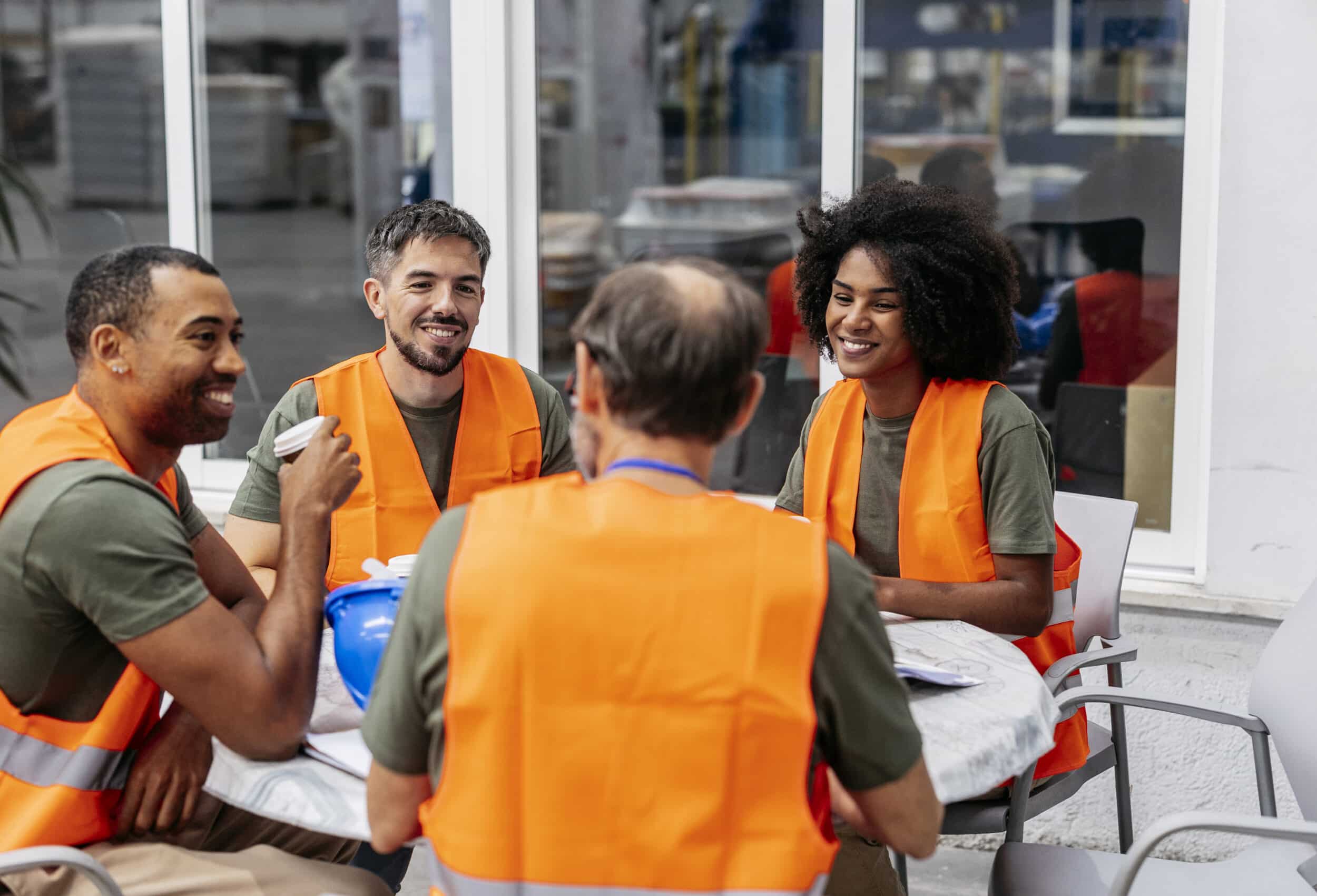 Group of delivery drivers smiling whilst having a meeting