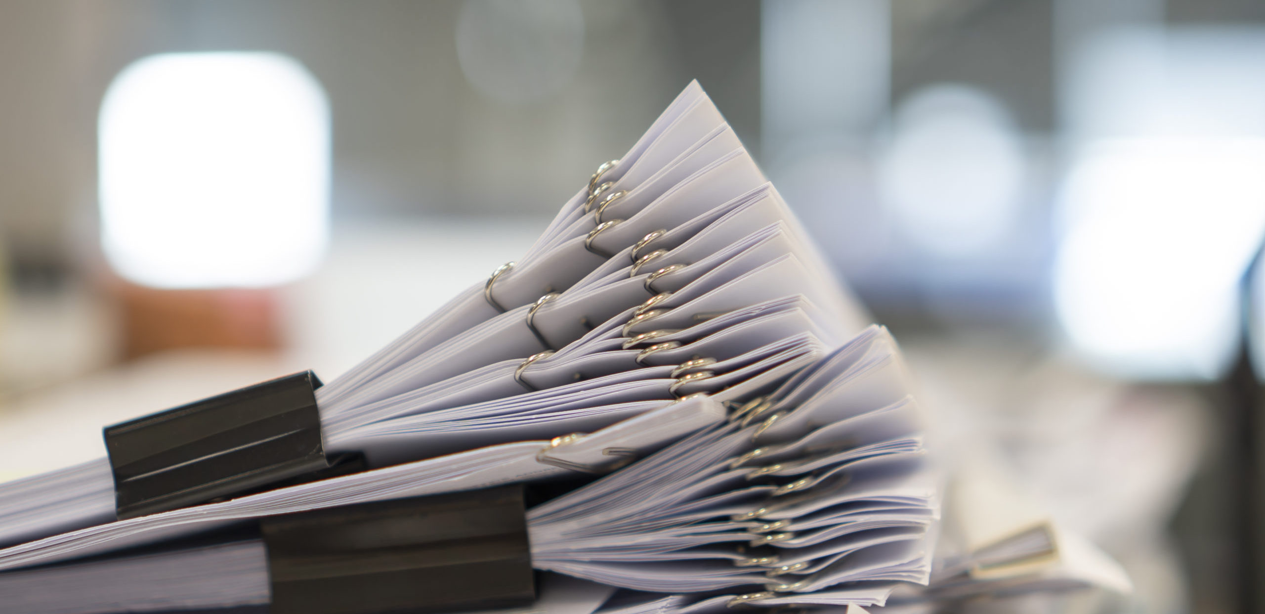 A stack of paper with bulldog clips
