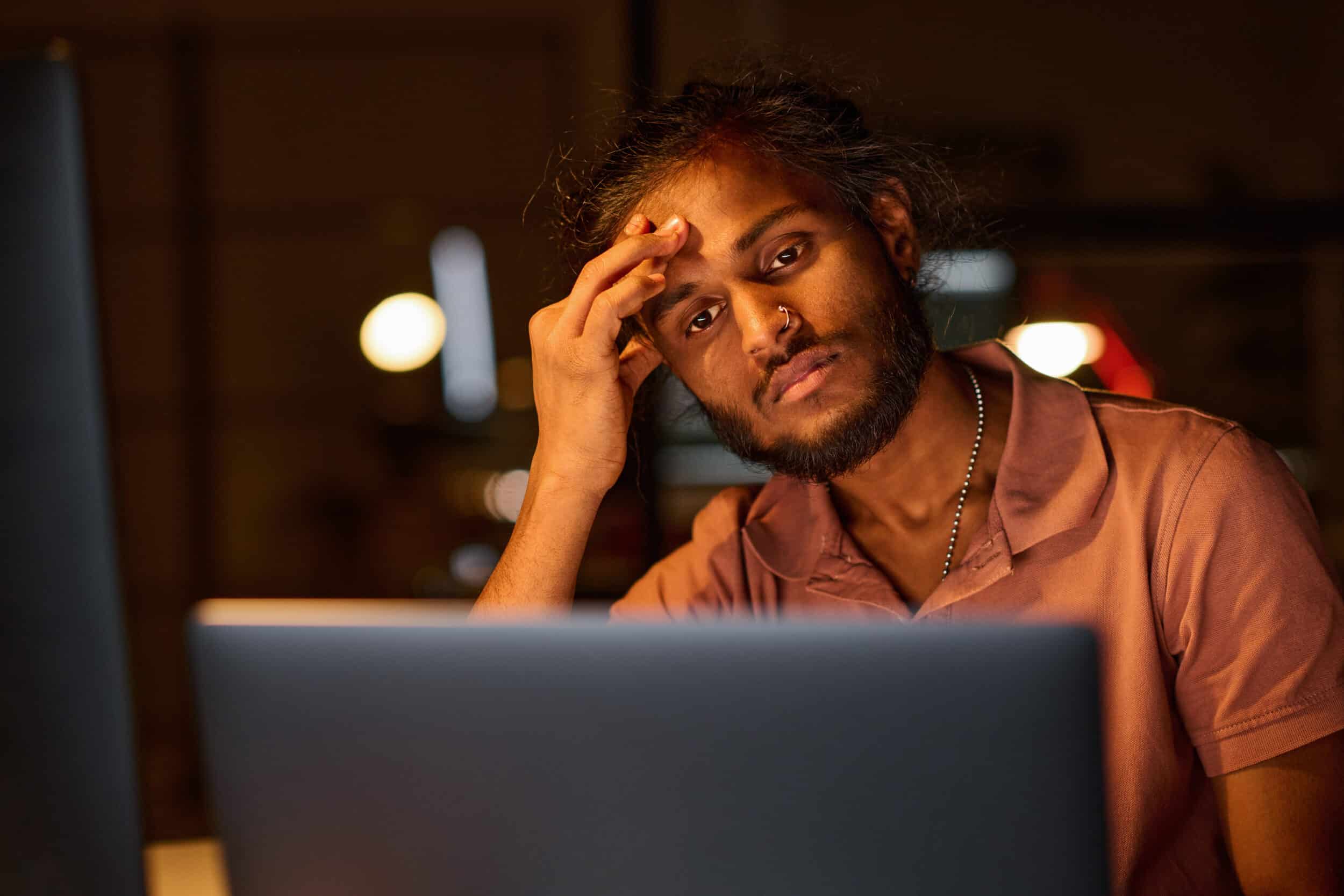 A frustrated warehouse worker looking at his laptop, trying to work through incomplete and poor data