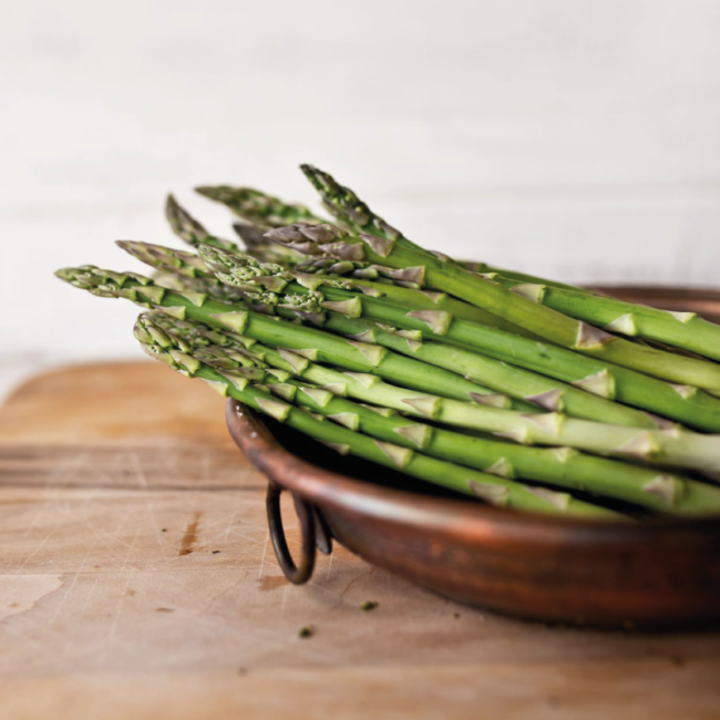 Asparagus in a wooden bowl on a wooden table
