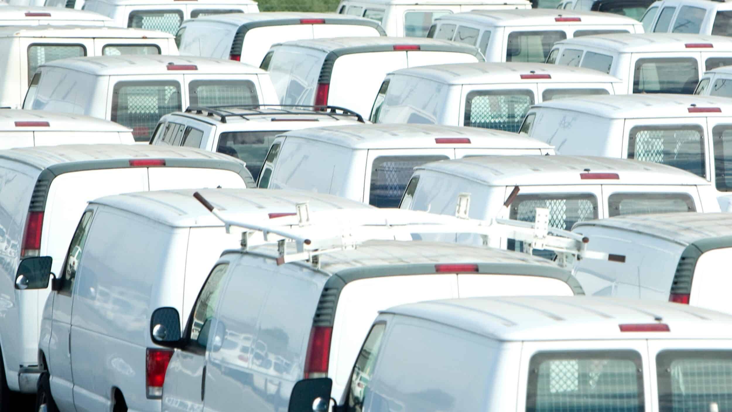 Car park full of white vans which businesses have added due to scaling thanks to route planning software