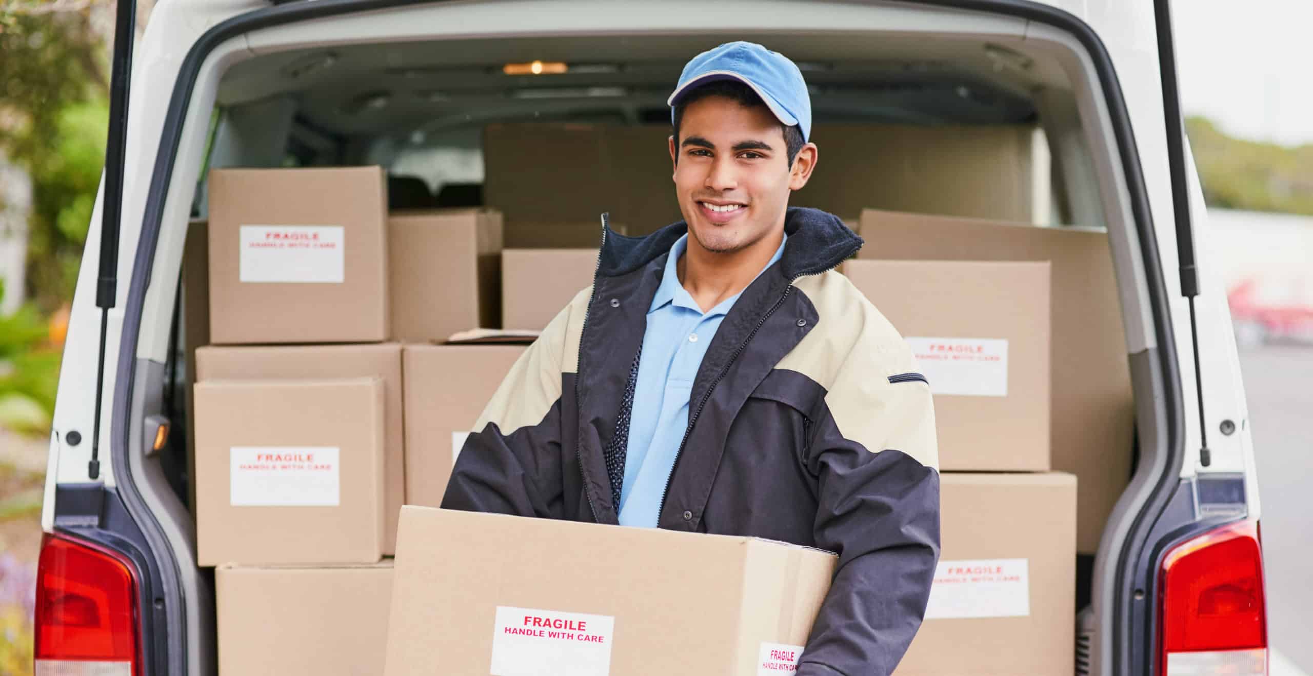 Delivery man with van open, holding a box